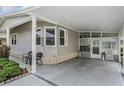 Home's covered carport features a cozy sitting area and access to the enclosed front porch at 5733 Pawnee St, Zephyrhills, FL 33542