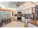 Kitchen features white cabinets, updated appliances, tile flooring, and breakfast nook at 5733 Pawnee St, Zephyrhills, FL 33542