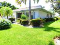 Side view of house showcasing well-manicured lawn and landscaping at 2501 Lonigan Pl, Sun City Center, FL 33573