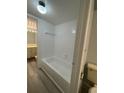 Clean bathroom with a bathtub, tiled walls, and light gray flooring at 14105 Mossy Glen Ln # 202, Tampa, FL 33613