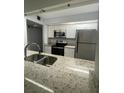 Modern kitchen featuring granite countertops, stainless steel appliances, and white cabinets at 14105 Mossy Glen Ln # 202, Tampa, FL 33613