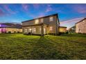 Expansive backyard featuring a covered patio, lush lawn and exterior view of the home at 33346 Kateland Dr, Wesley Chapel, FL 33545