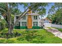 Two-story house with green and white exterior and a large tree in the yard at 5297 Huntington Ne St, St Petersburg, FL 33703