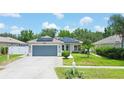 House exterior with gray garage door, solar panels, and landscaped lawn at 4504 Horseshoe Pick Ln, Valrico, FL 33594