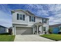 Two-story house with gray siding, gray garage door, and landscaping at 17206 White Mangrove Dr, Wimauma, FL 33598