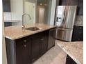 Modern kitchen with dark cabinets, granite counters, and stainless steel appliances at 4115 Murfield E Dr, Bradenton, FL 34203