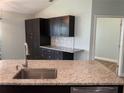Modern kitchen with dark cabinets, granite counters and stainless steel appliances at 4115 Murfield E Dr, Bradenton, FL 34203