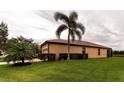 Tan house with brown roof, palm trees, and well-manicured lawn at 8044 Stirling Falls Cir, Sarasota, FL 34243