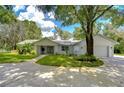 Newly renovated home showcasing a spacious yard and driveway at 913 Briggett Ln, Lutz, FL 33548