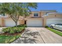 Tan townhome exterior with two-car garage and landscaping at 184 Valencia Cir, St Petersburg, FL 33716