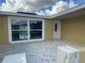 Covered patio with marble-look tile flooring and stylish entryway at 7134 Brentwood Dr, Port Richey, FL 34668