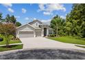 Two-story house with three-car garage and landscaping at 31421 Anniston Dr, Wesley Chapel, FL 33543
