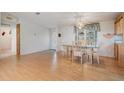 Dining area with wood-look floors and a glass table at 37700 Neukom Ave, Zephyrhills, FL 33541