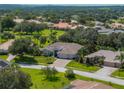 Landscaped property with a large home, three-car garage, and mature trees at 13216 Legends Trl, Dade City, FL 33525