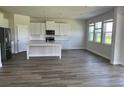 Open-concept kitchen boasts stainless steel appliances, white cabinetry, and a large center island at 908 160Th E Ln, Bradenton, FL 34212