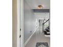 Bright entryway with gray walls, tile floors, and a staircase leading upstairs at 17350 Garden Heath Ct, Land O Lakes, FL 34638