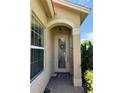 Front entry with arched doorway and decorative glass at 15953 Cobble Mill Dr, Wimauma, FL 33598