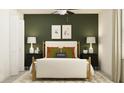 Bedroom with a double bed, green accent wall, and modern nightstands at 12479 Sweet Angel Aura Way, Parrish, FL 34219