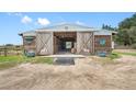 Spacious horse barn with large wooden doors and well-maintained stalls, a horse lover's dream at 8602 State Road 674, Wimauma, FL 33598