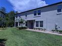 A gray two-story townhome with a front door and neatly landscaped lawn at 10066 Corso Milano Dr, Tampa, FL 33625