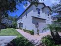 Two-story townhome showcasing its side elevation, with landscaping and a brick walkway at 10066 Corso Milano Dr, Tampa, FL 33625