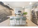 Contemporary kitchen with an island, geometric backsplash, and stylish barstools at 2714 Chestnut Creek Pl, Brandon, FL 33510