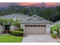 Close up of the exterior showing a two-car garage with a brick driveway and manicured yard at 604 Masterpiece Dr # 604, Sun City Center, FL 33573