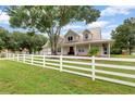 House exterior with a metal roof, white fence, and a well-manicured lawn at 17513 Marsh Rd, Lutz, FL 33558