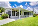 Single-wide manufactured home with covered patio and lush landscaping at 6048 Ridgeway Dr, Zephyrhills, FL 33542