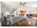 Open living space with hardwood floors, staged furniture, and kitchen views at 6536 Northlake Dr, Zephyrhills, FL 33542