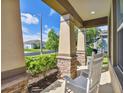 Front porch with rocking chairs and stone columns at 32527 Harmony Oaks Dr, Wesley Chapel, FL 33545