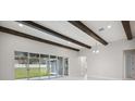 Modern living room with wooden beams, recessed lighting, and sliding glass doors leading to the backyard at 157 Hidden Estates Ct, Brandon, FL 33511
