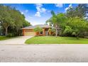 Orange house with a two-car garage and lush lawn at 239 147Th Ne St, Bradenton, FL 34212