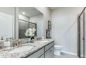 Double vanity bathroom with granite countertop and a walk-in shower at 18330 Cropside Trl, Lakewood Ranch, FL 34211