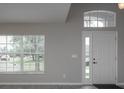 Bright entryway with white door, large window, and gray walls at 31147 Whinsenton Dr, Wesley Chapel, FL 33543