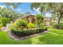 Landscaped front yard with lush greenery and a well-maintained lawn at 7219 Wareham Dr, Tampa, FL 33647