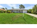 Ranch style home with a gray exterior, a large front yard, and a for sale sign at 455 Lenoir Nw St, Port Charlotte, FL 33948