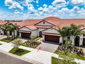 Two-story townhome with a Mediterranean style and two-car garage at 17231 Holly Well Ave, Wimauma, FL 33598