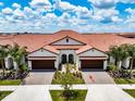 Two-story townhome with a Mediterranean style and two-car garage at 17231 Holly Well Ave, Wimauma, FL 33598
