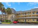 Two-story condo building with palm trees and parking at 8699 Bardmoor Blvd # 304, Seminole, FL 33777