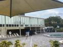 Community pool with lounge chairs and adjacent building at 2310 Denmark St # 50, Clearwater, FL 33763