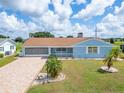 Charming single-story home with a brick exterior, well-manicured lawn, and attached garage at 609 Fox Hills Dr, Sun City Center, FL 33573