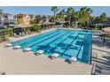 Inviting community pool with lap lanes, a ' area, lounge chairs, and shade umbrellas at 7134 Heather Sound Loop, Wesley Chapel, FL 33545