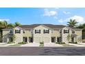 Three-unit townhome building with attached garages and landscaping at 17208 Bigleaf Mahogany Ln, Land O Lakes, FL 34638