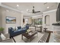 Bright living room with hardwood floors, stone fireplace, and sliding glass doors to the outdoor living area at 331 Star Shell Dr, Apollo Beach, FL 33572