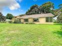 Back exterior view of the house showcasing a large lawn at 13400 Norman Cir, Hudson, FL 34669
