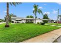 Front view of a ranch home with a well-maintained lawn at 7015 Flaggler Dr, Port Richey, FL 34668