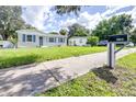Newly built single-Gathering home with blue shutters and a green lawn at 2102 E Annie St, Tampa, FL 33612