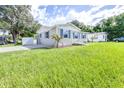 Newly built single-Gathering home with blue shutters and a green lawn at 2102 E Annie St, Tampa, FL 33612