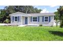 Newly built single-Gathering home with blue shutters and a green lawn at 2102 E Annie St, Tampa, FL 33612